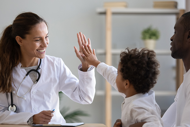 A Hollytree Health provider high-fives a young patient during a visit